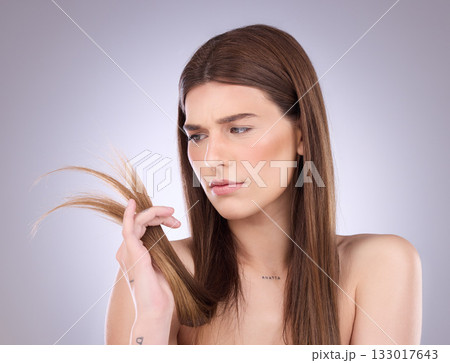 Woman, worry and split ends in studio, background and beauty concern of hair loss, problem and damage. Worried, unhappy and female model check tips of haircare, hairstyle and treatment of dry texture 133017643