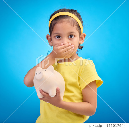 Piggy bank, shocked or surprised child in portrait isolated on blue background savings mistake or investment risk. Wow face of girl kid and saving jar or container for finance or money fear in studio Piggy bank, shocked or surprised child in portrait isolated on blue background savings mistake or investment risk. Wow face of girl kid and saving jar or container for finance or money fear in studio 133017644