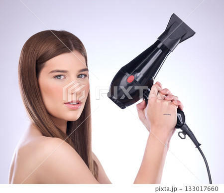 Hair, dryer and portrait of woman in studio for beauty, grooming and heat styling on background. Young female model, haircare and tools for straight hairstyle, drying or salon appliance for treatment Hair, dryer and portrait of woman in studio for beauty, grooming and heat styling on background. Young female model, haircare and tools for straight hairstyle, drying or salon appliance for treatment 133017660