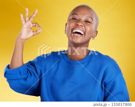 Portrait, laughing and black woman with ok sign in studio isolated on a yellow background. Success, emoji face and happy, comic and funny female with hand gesture for okay, support or perfection. Portrait, laughing and black woman with ok sign in studio isolated on a yellow background. Success, emoji face and happy, comic and funny female with hand gesture for okay, support or perfection. 133017800