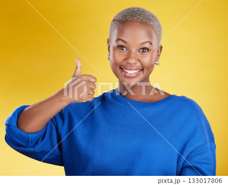 Portrait, smile and black woman with thumbs up in studio isolated on a yellow background. Success, emoji face and happy African female with hand gesture for agreement, support or approval, like or ok 133017806