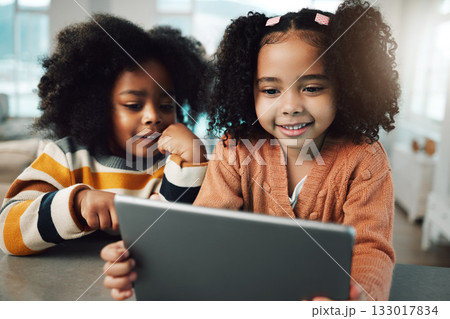 Children, sisters and girls smile with tablet in home, playing games and bonding together. Technology, family and happy kids with touchscreen for elearning, streaming movie and video. 133017834