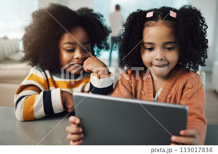 Sisters, children and girls smile with tablet in home, playing games and bonding together. Technology, family and happy mixed race kids with touchscreen for elearning, streaming movie or web browsing 133017838