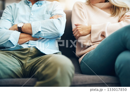 Divorce, angry and couple fight arms crossed due to family law problem in a marriage with conflict in a home lounge. Anger, living room and partner or people frustrated, depressed and mad on a sofa 133017850