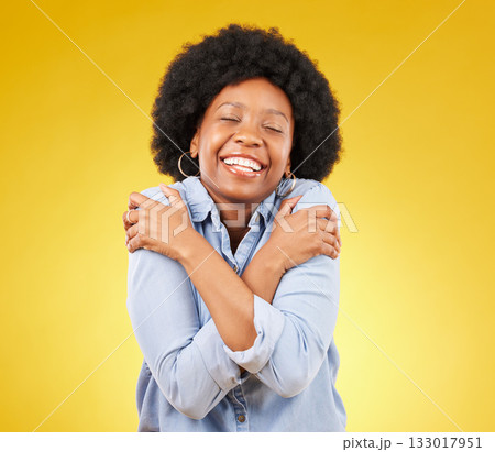 Black woman, happy with self love and hug body, smile and joy with eyes closed on yellow studio background. Female is cheerful, wellness and positive mindset with mockup space, happiness and selfcare 133017951