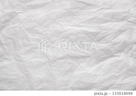 Crumpled white paper sheet with creases and wrinkles forming textured, distressed abstract background with copy space and vintage feel 133018099