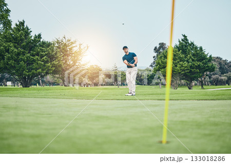 Grass, golf hole and man with golfing club on course for game, practice and training for competition. Professional golfer, sports and male athlete hit ball with club for winning, score or tee stroke 133018286