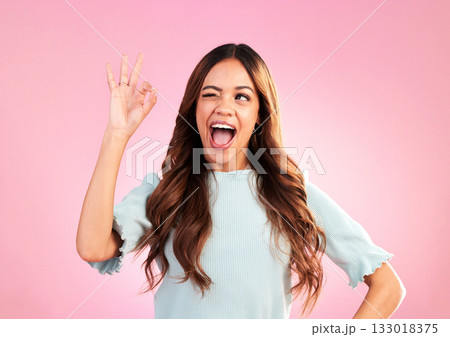 Wink, studio and woman with a perfect hand gesture, excitement and positive face expression. Happy, smile and young female model from Colombia with a ok sign language isolated by a pink background. Wink, studio and woman with a perfect hand gesture, excitement and positive face expression. Happy, smile and young female model from Colombia with a ok sign language isolated by a pink background. 133018375