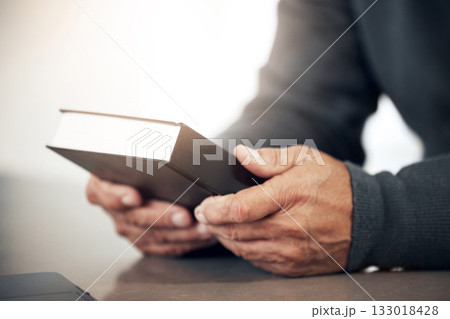 Book, prayer or bible with hands of man for holy worship, support or hope in Christianity or faith. Believe, religion or zoom of catholic person praying to God in spiritual literature for wellness 133018428