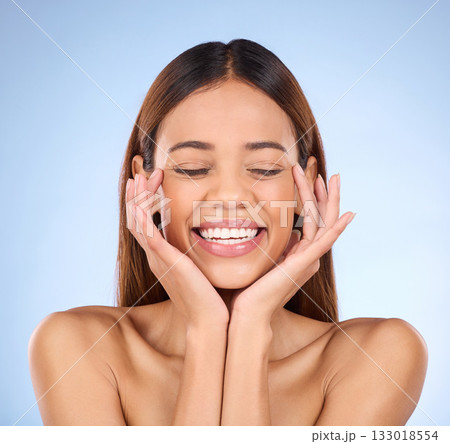 Skincare, beauty and happy woman touching face with smile for skin care glow promo on blue background. Makeup, facial massage and cosmetics, hispanic model for dermatology spa promotion in studio. Skincare, beauty and happy woman touching face with smile for skin care glow promo on blue background. Makeup, facial massage and cosmetics, hispanic model for dermatology spa promotion in studio. 133018554