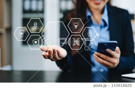 Professional using smartphone with digital holographic dental icons, showcasing innovation, modern healthcare technology, and advanced dentistry solutions Professional using smartphone with digital holographic dental icons, showcasing innovation, modern healthcare technology, and advanced dentistry solutions 133018820