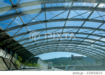 ゴルフ場近くの道路上に掛かる飛球防護柵 133019213