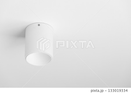 A clean, white cylindrical ceiling light fixture with a simple, modern design 133019334
