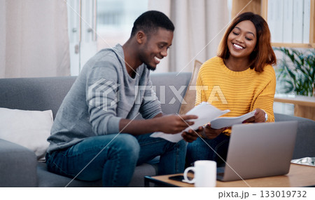 Home, smile and black couple with paperwork, laptop and discussion with budget, conversation and planning funding. Partnership, man and woman with technology, talking and documents for investments 133019732