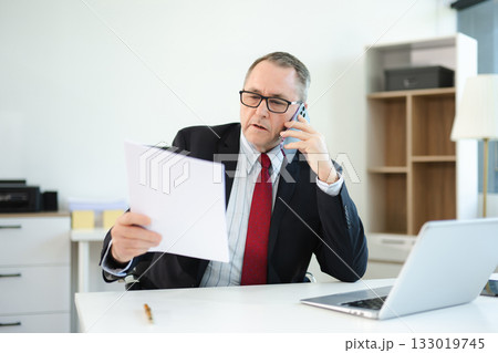Professional businessman working at office with laptop, tablet, and notes. Perfect for business, finance, accounting, 133019745