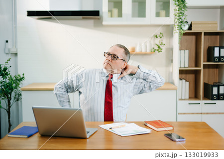 Overworked businessman office worker suffering from neck pain after had a long day at desk. office syndrome concept Overworked businessman office worker suffering from neck pain after had a long day at desk. office syndrome concept 133019933