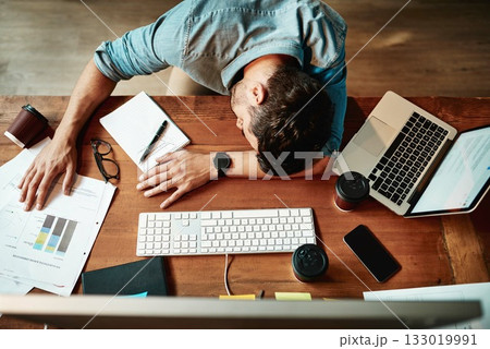 Top view, tired man and sleeping at desk in office with burnout, bored and stress. Fatigue, lazy and overworked business employee taking nap at table for frustrated deadline, depression or low energy Top view, tired man and sleeping at desk in office with burnout, bored and stress. Fatigue, lazy and overworked business employee taking nap at table for frustrated deadline, depression or low energy 133019991