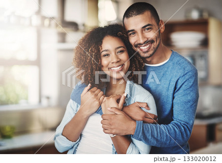Love, portrait and happy couple hug in kitchen of home with smile, embrace and healthy relationship. Happiness, man and woman hugging in affection, romance and care in marriage, young people in house 133020012