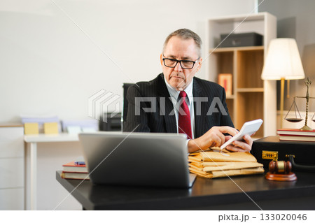 Mature Male judge in a courtroom on white table and Counselor or Male lawyer working in office. Justice and law concept 133020046