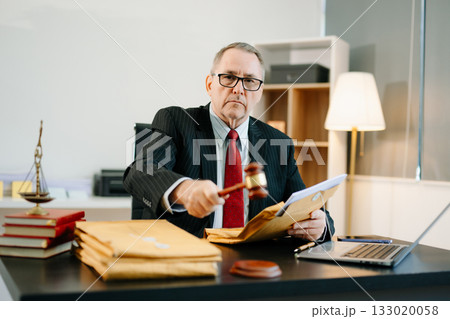 Male judge in courtroom, lawyer working in office. Perfect for business, legal advice, corporate law, and professional consulting themes. Male judge in courtroom, lawyer working in office. Perfect for business, legal advice, corporate law, and professional consulting themes. 133020058