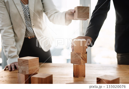 Hands, wood building blocks and business people in partnership with strategy, problem solving and support. Teamwork, wooden toys and together with puzzle, synergy and mindset for solution in office 133020076