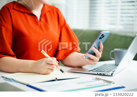 businesswoman hand writing on the notepad with new modern computer strategy diagram as concept 133020222