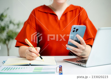 businesswoman hand writing on the notepad with new modern computer strategy diagram as concept businesswoman hand writing on the notepad with new modern computer strategy diagram as concept 133020223
