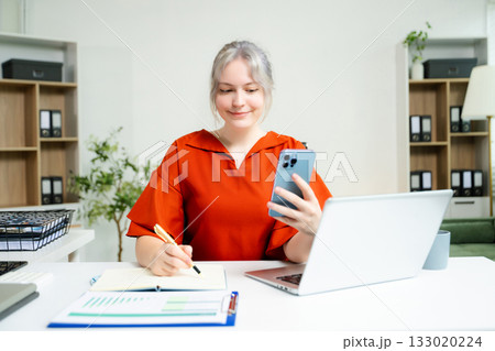 Confident business expert attractive smiling young woman holding digital tablet on desk in creative office. Confident business expert attractive smiling young woman holding digital tablet on desk in creative office. 133020224