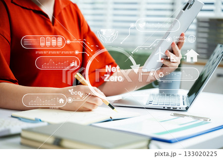 Businesswoman working virtual tablet computer twith reduce CO2 concept with icons, global warming such as reforest green factory recycle in office Businesswoman working virtual tablet computer twith reduce CO2 concept with icons, global warming such as reforest green factory recycle in office 133020225