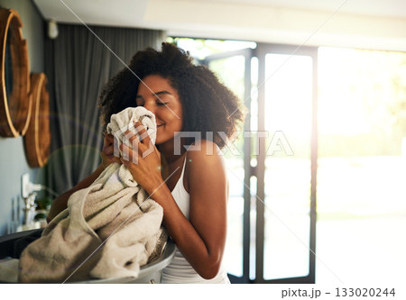 Laundry smell, african woman and cleaning chores with happiness and calm in home. Smile, fresh clothes and lens flare with washing of a black female person in a house feeling relax in the morning 133020244