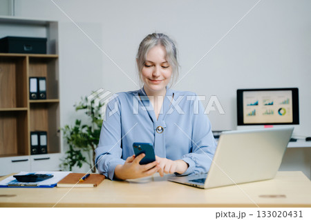 Business woman using tablet and laptop for doing math finance on an office desk, tax, report, accounting, statistics, and analytical research concept 133020431