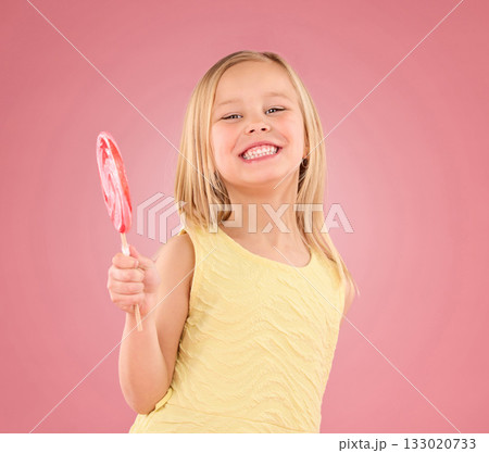 Candy, smile and lollipop with portrait of girl in studio for sugar, party and carnival food isolated on pink background. Cute, positive and youth with child and eating snack for playful and treats Candy, smile and lollipop with portrait of girl in studio for sugar, party and carnival food isolated on pink background. Cute, positive and youth with child and eating snack for playful and treats 133020733