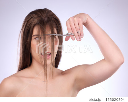 Beauty, salon and a woman self cutting her hair in studio on a gray background for style or care. Grooming, shampoo and haircut with an attractive young female trimming her bangs for haircare 133020804