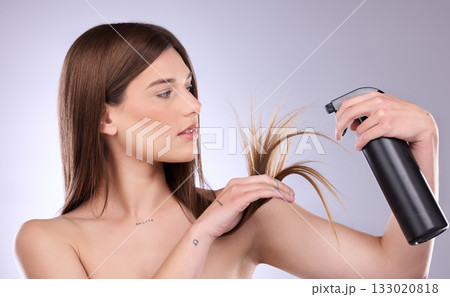 Hair care, split ends and woman with spray in studio isolated on a gray background. Cosmetics product, damage and female model with hairspray bottle for salon treatment and hairstyle moisturizer. 133020818