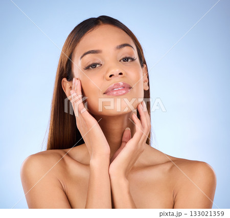 Woman, portrait and face in beauty skincare cosmetics or self love and care against a blue studio background. Happy female with lip gloss touching perfect skin in satisfaction for facial treatment Woman, portrait and face in beauty skincare cosmetics or self love and care against a blue studio background. Happy female with lip gloss touching perfect skin in satisfaction for facial treatment 133021359