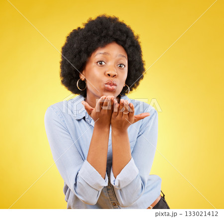 Happy, blowing kiss and portrait of black woman in studio for confidence, flirting and romance. Self love, relax and desire with female on yellow background for positive, sensual and proud gesture 133021412