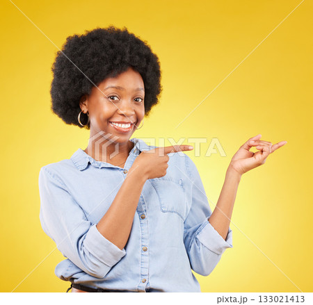 Happy, portrait of a black woman in studio pointing at mockup space for advertising or marketing. Happiness, smile and African female model showing mock up for product placement by yellow background. 133021413