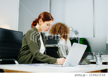 Two women coding together in a high-tech office, showcasing teamwork, software development, and female empowerment 133021510