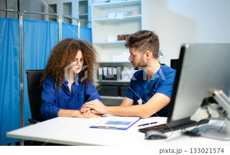 A compassionate doctor comforts a stressed female patient during a sensitive consultation. Concept of empathy, support 133021574