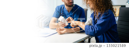 Female patient gets blood pressure checked by doctor with digital monitor. Health checkup, patient care, and medical technology Female patient gets blood pressure checked by doctor with digital monitor. Health checkup, patient care, and medical technology 133021589