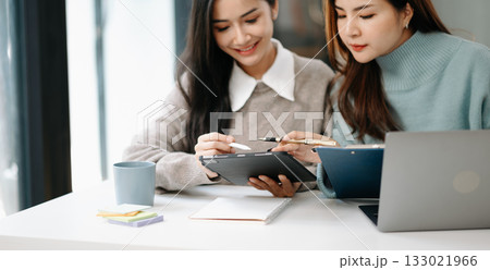 Happy businesspeople while collaborating on a new project in office. team of diverse business using a laptop and tablet in office. Happy businesspeople while collaborating on a new project in office. team of diverse business using a laptop and tablet in office. 133021966