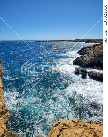 Experience the stunning and breathtaking coastal view with rolling waves and a clear blue sky Experience the stunning and breathtaking coastal view with rolling waves and a clear blue sky 133022010