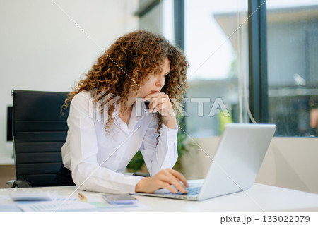 Successful businesswoman in office working on laptop.for doing math finance on an office desk, tax, report 133022079