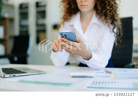 Successful businesswoman in office working on laptop.for doing math finance on an office desk, tax, report Successful businesswoman in office working on laptop.for doing math finance on an office desk, tax, report 133022127