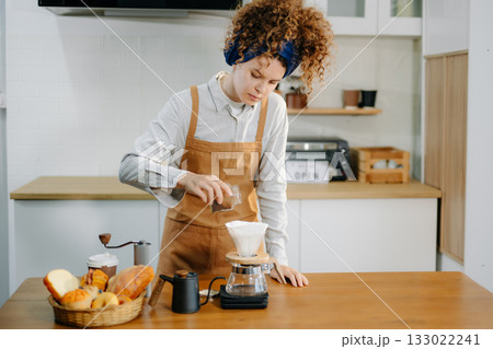 Caucasian barista brewing fresh espresso. Enjoy a cozy, trendy cafe experience with high quality beans in home or cafe Caucasian barista brewing fresh espresso. Enjoy a cozy, trendy cafe experience with high quality beans in home or cafe 133022241