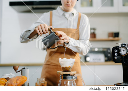 Closeup of barista brewing pour over coffee at home. Warm lifestyle concept featuring hand-crafted drip process, 133022245