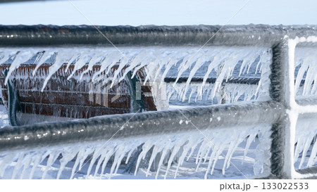 Beautiful Icicles Forming on a Metal Fence with Sunlight Creating a Sparkling Effect in Winter Beautiful Icicles Forming on a Metal Fence with Sunlight Creating a Sparkling Effect in Winter 133022533