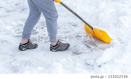 Man shoveling snow off of his driveway after a winter storm in Canada. Man with snow shovel cleans sidewalks in winter. Winter time. 133022536