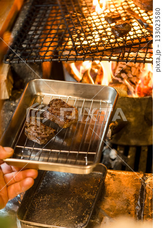 薪火で焼き上げる肉料理 炎が立ち上る炭火グリルの臨場感 薪火で焼き上げる肉料理 炎が立ち上る炭火グリルの臨場感 133023580