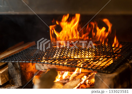 薪火で焼き上げる肉料理 炎が立ち上る炭火グリルの臨場感 薪火で焼き上げる肉料理 炎が立ち上る炭火グリルの臨場感 133023581